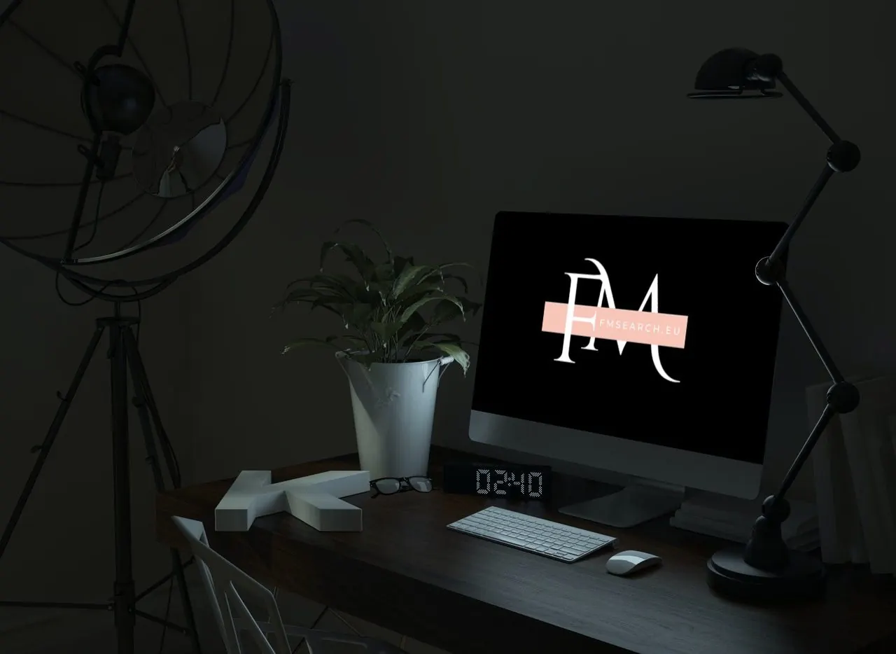 Desk with a computer showing the FM Search logo